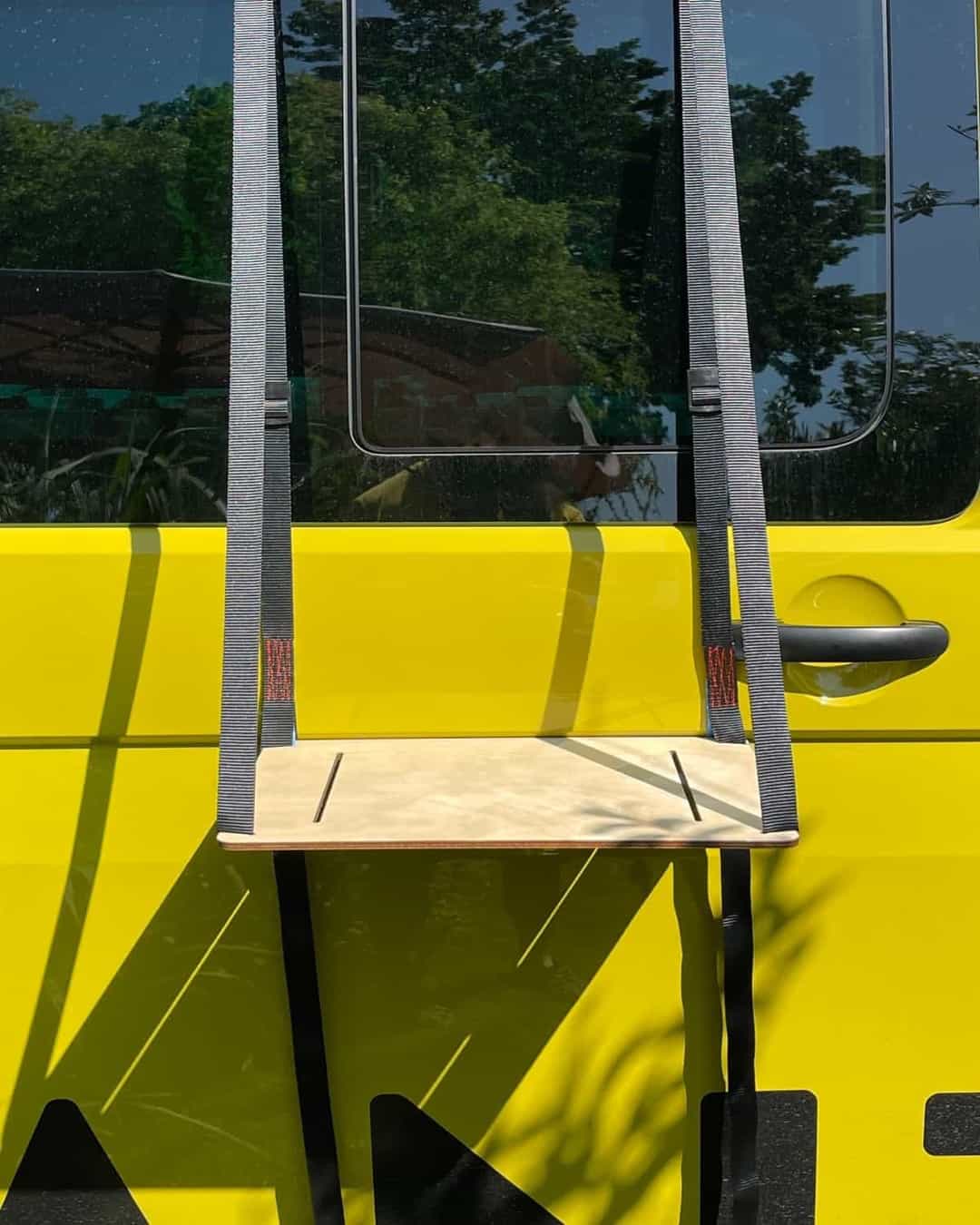 The outdoor table hangs stably from the door with a wide strap.