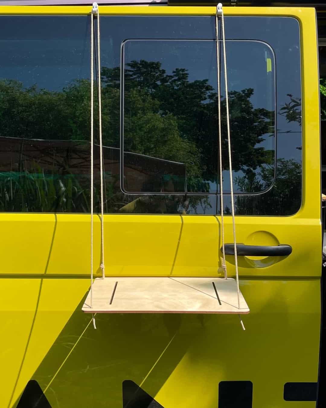 The camping table hangs securely from the van using a natural fibre rope.