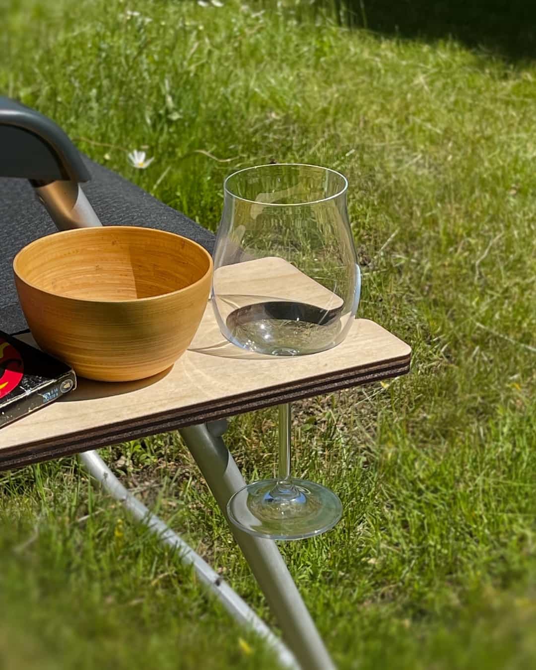 Wine glass holder The tray on the chair holds a wine glass with a stem securely in the special holder.