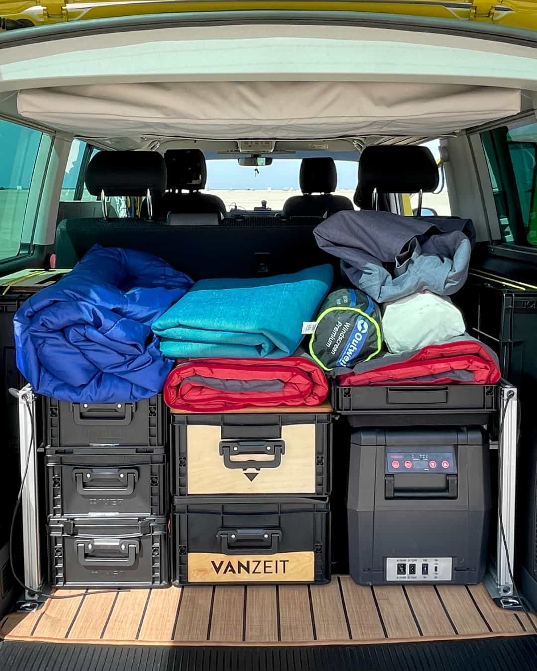 A travel-ready camper unit is packed in the back of the van.
