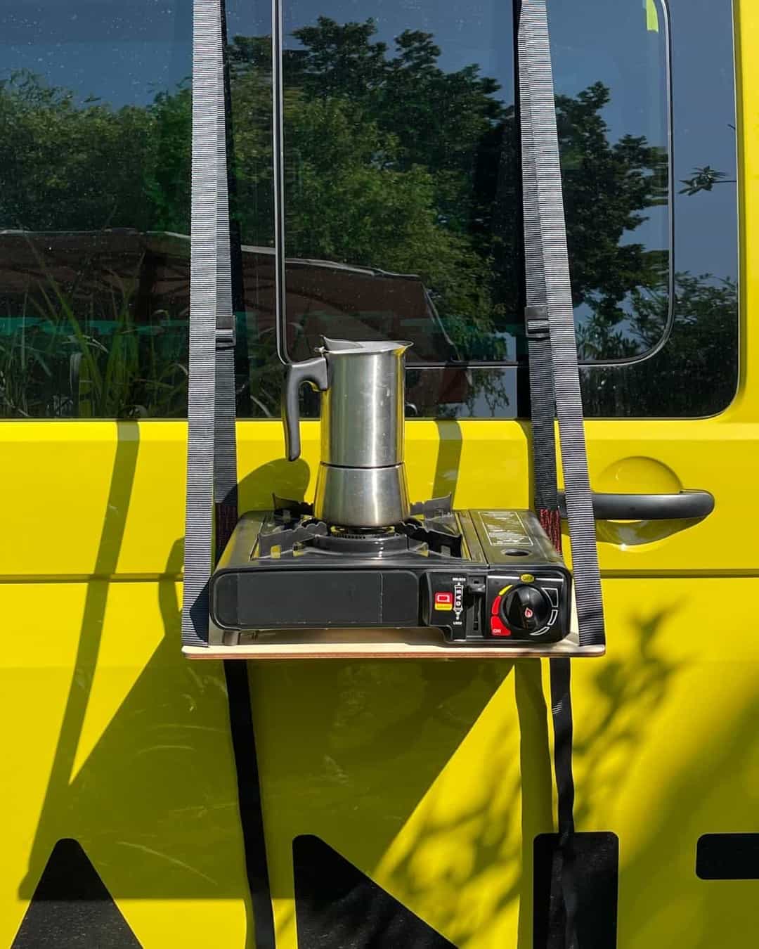Kochen am Außentisch des VW Bus Ein Mokkakocher und ein Gasgrill stehen auf dem Außentisch am VW T6.