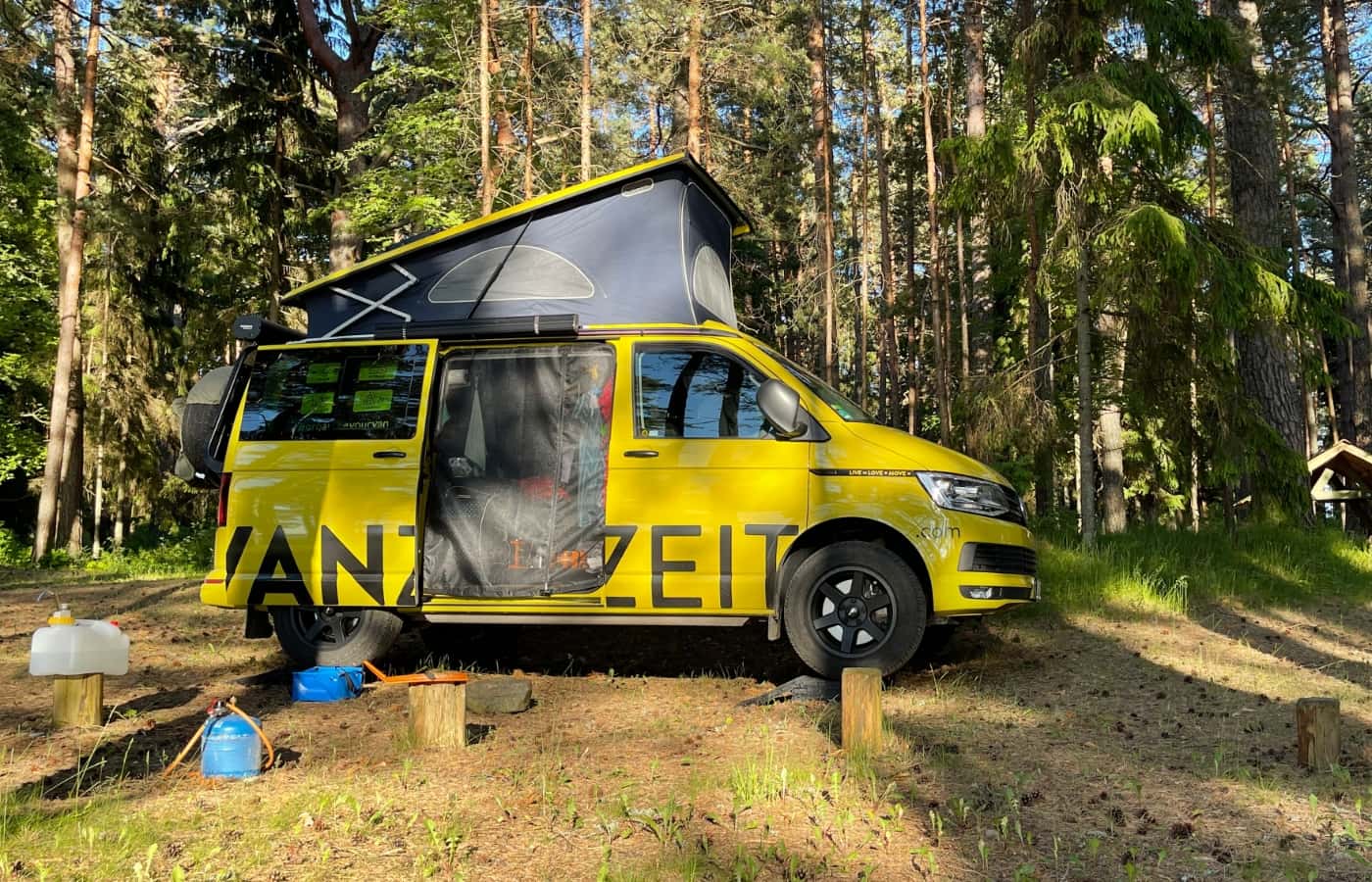 autarker VW California T6 Beach steht im Wald an der estländischen Ostsee