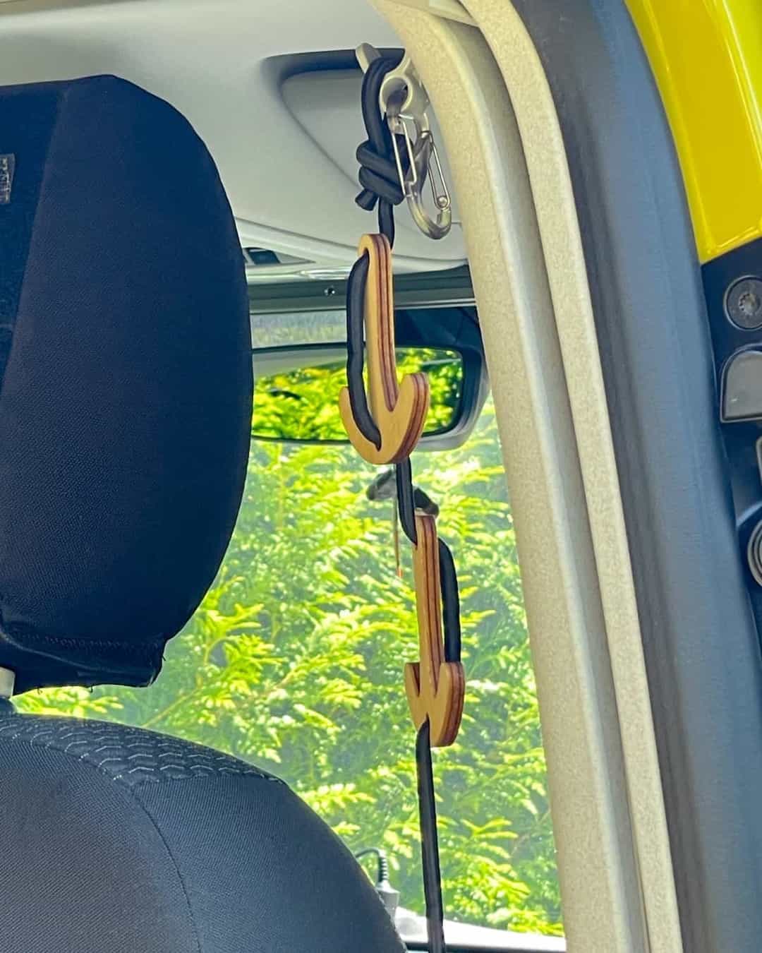 There is a coat rack with four hooks attached to the B-pillar of the VW bus.