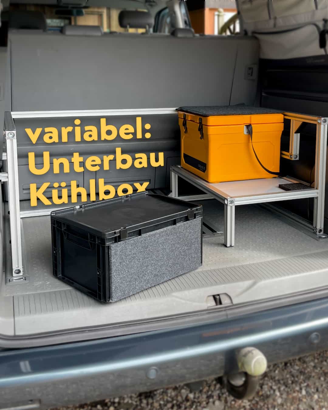 Ein variabler Kühlboxträger ist an einer Campingbox montiert.